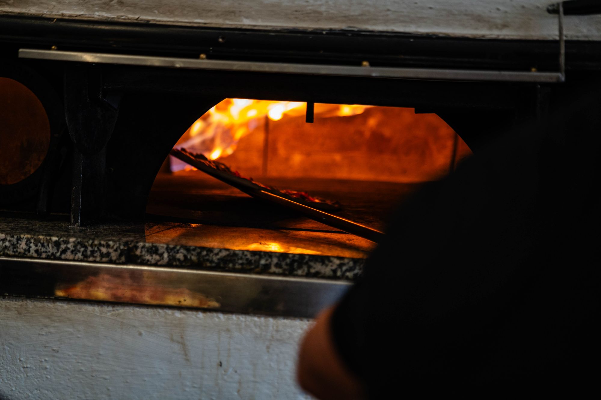 Pizza wird im Ristorante Colosseo frisch geschnitten und serviert