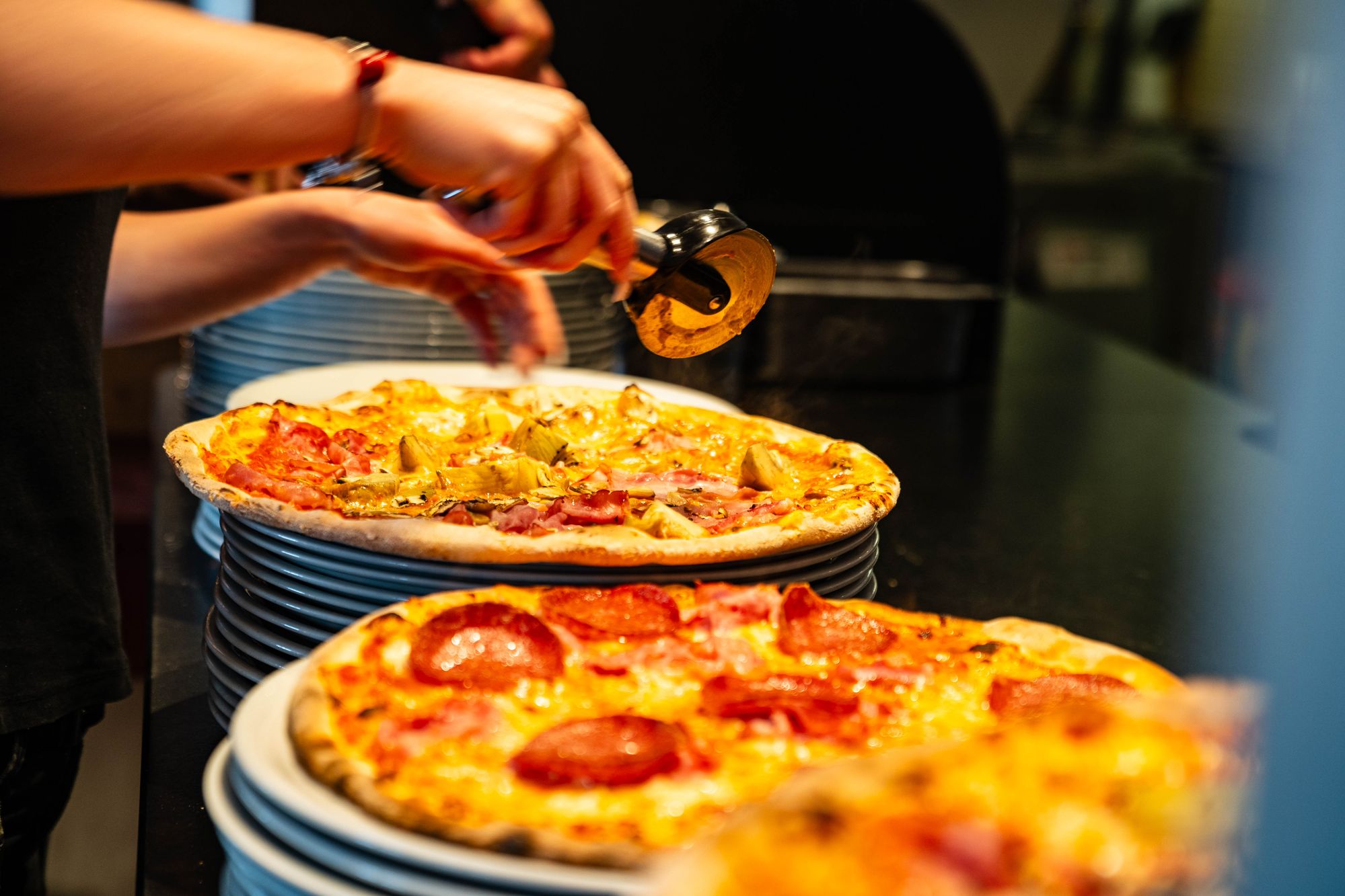 Frisch zubereitete Pizzen in der Küche des Ristorante Colosseo
